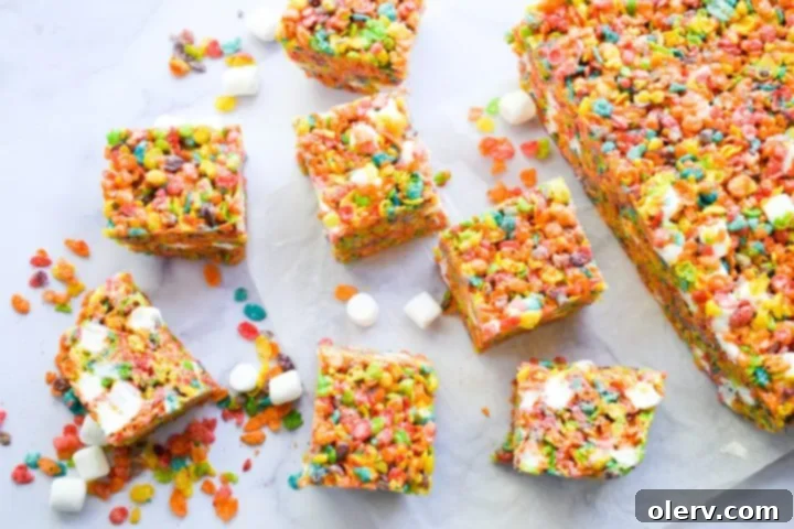 Ultimate Fruity Pebbles Bars 2 Vibrant Fruity Pebbles Cereal Bars on a cutting board, showcasing their colorful, chewy texture.