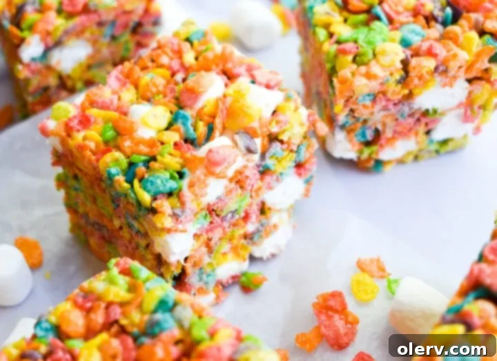 Ultimate Fruity Pebbles Bars 5 Hands pressing the colorful Fruity Pebbles and marshmallow mixture into a prepared baking pan.