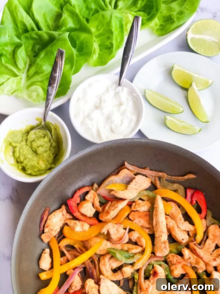 Low-Carb Chicken Fajita Lettuce Wraps 3 A close-up of a single lettuce wrapped chicken fajita, showcasing the vibrant chicken and vegetables.