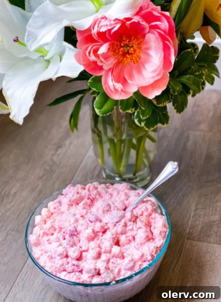Cherry Cloud Delight 6 All the ingredients for Cherry Fluff Salad laid out on a wooden board: Cool Whip, cherry pie filling, crushed pineapple, condensed milk, marshmallows, and shredded coconut.