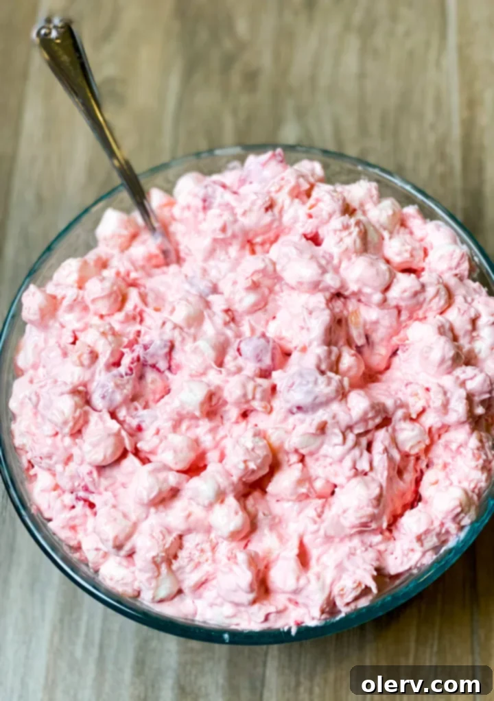 Cherry Cloud Delight 8 Cherry Fluff Salad in a large glass bowl with a serving spoon.