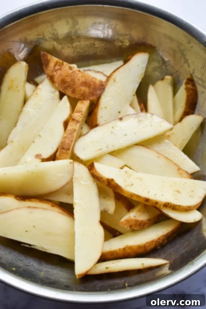 Mouthwatering Seasoned French Fries 8 Seasoned potatoes spread on a baking sheet, ready for the oven or air fryer
