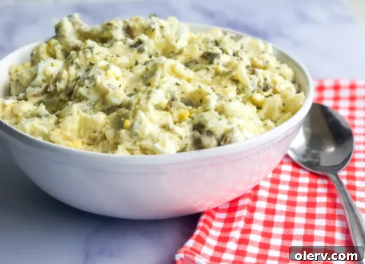 Effortless Instant Pot Potato Salad 4 Diced potatoes being tossed in a mixing bowl with the classic potato salad dressing.