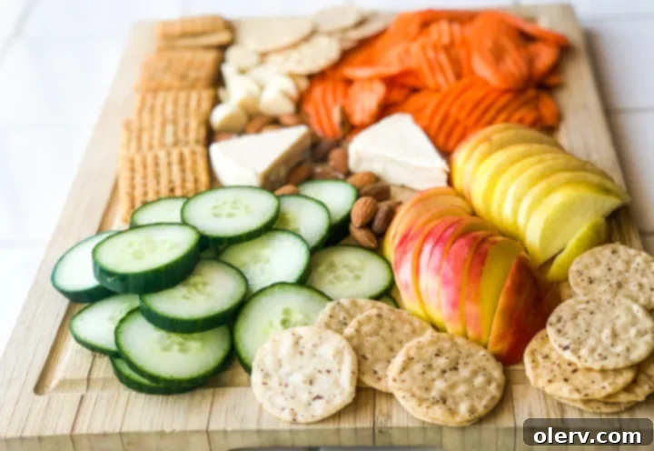 Effortless Summer Bites 3 Close-up of a summer charcuterie board showcasing a variety of colorful fruits, vegetables, and creamy cheese for dipping.