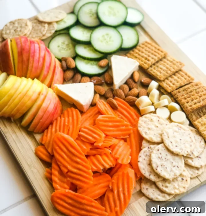 Effortless Summer Bites 4 A close-up shot of Laughing Cow cheese wedges, perfectly positioned on a snack board, ready for dipping with fresh produce.