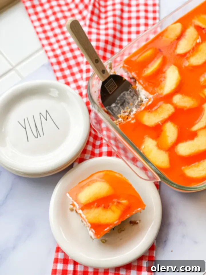 A pan of freshly prepared Peaches & Cream Pretzel Salad, garnished and ready to be sliced.