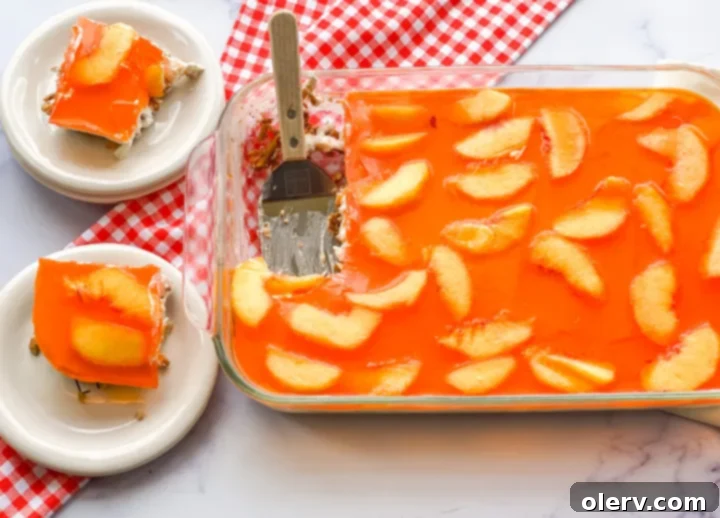 A single serving of Peaches & Cream Pretzel Salad, scooped onto a plate with a fork.