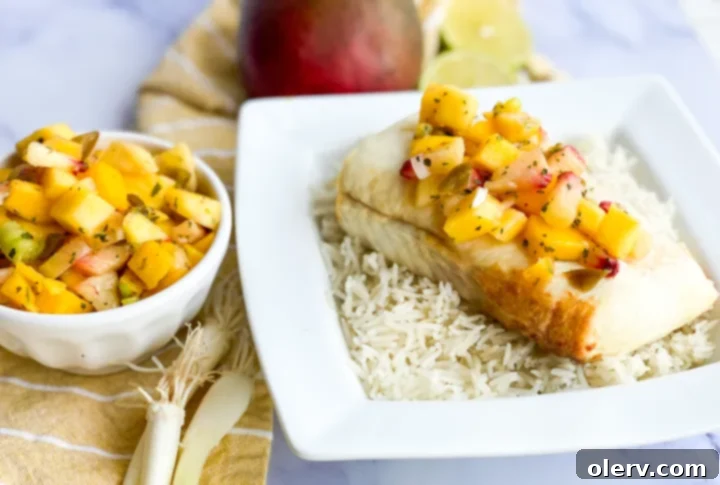Flaky Air Fryer Halibut with Zesty Mango Salsa 2 Delicious plate of air fryer halibut with vibrant mango salsa and coconut rice, ready to be enjoyed.