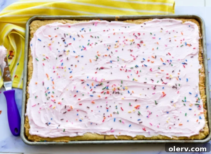 Heavenly Frosted Sugar Cookie Bars 2 Deliciously frosted sugar cookie bars, topped with colorful sprinkles, ready to be served at a party.