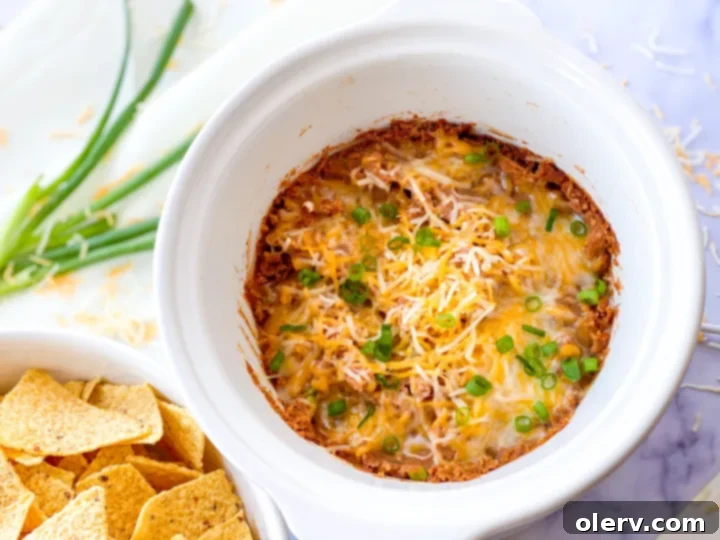 Effortless Slow Cooker Bean Dip 2 Delicious cheesy slow cooker bean dip served with tortilla chips, ready for dipping.