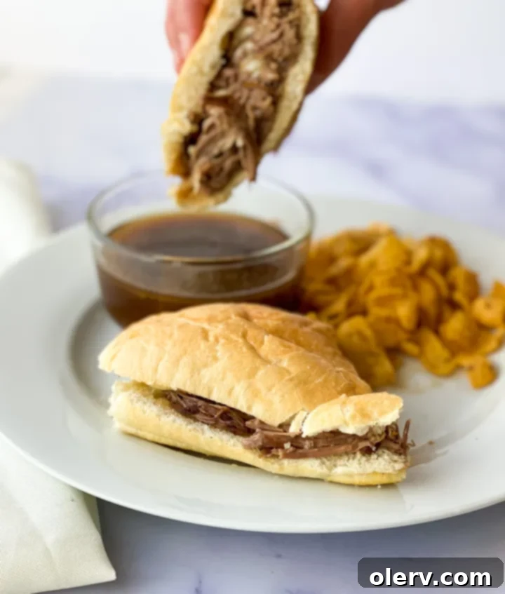 Ultimate Slow Cooker French Dip Sandwiches 6 A bowl of slow-cooked French Dip beef, beautifully shredded and ready to be loaded onto hoagie buns for delicious sandwiches.
