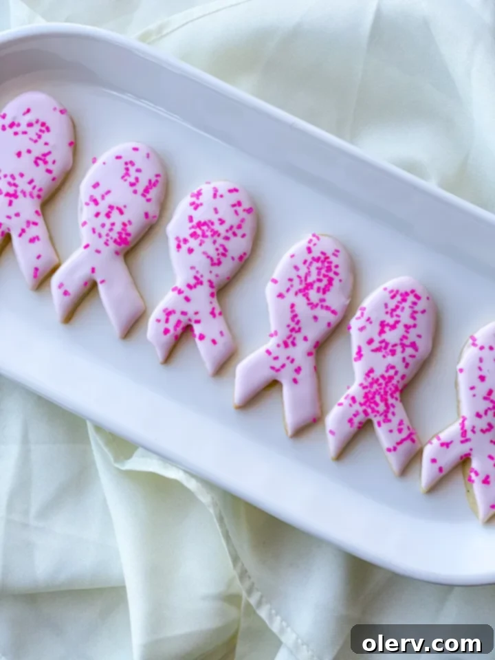 Pink Ribbon Cookie Treats 2 Pink ribbon sugar cookies, a symbol of Breast Cancer Awareness, beautifully decorated on a wooden surface.