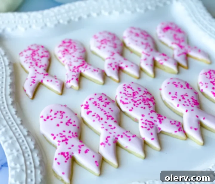 Pink Ribbon Cookie Treats 4 Hand holding a pink ribbon sugar cookie with sprinkles, symbolizing hope and support.