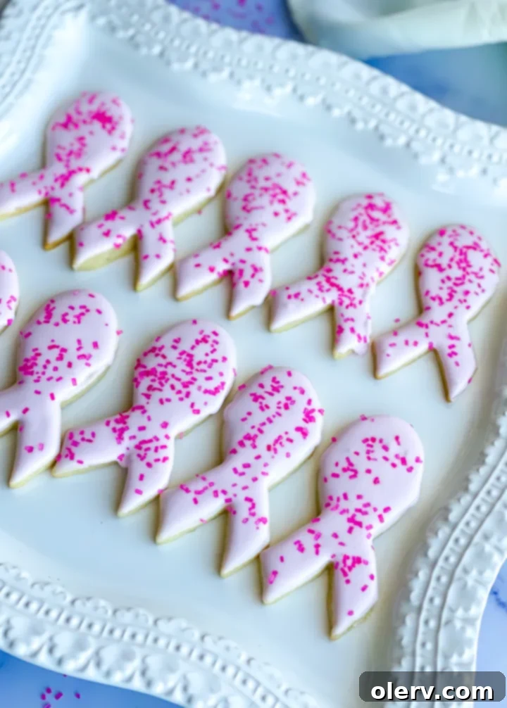 Pink Ribbon Cookie Treats 6 Various pink ribbon sugar cookies on a cooling rack, showcasing intricate frosting details.