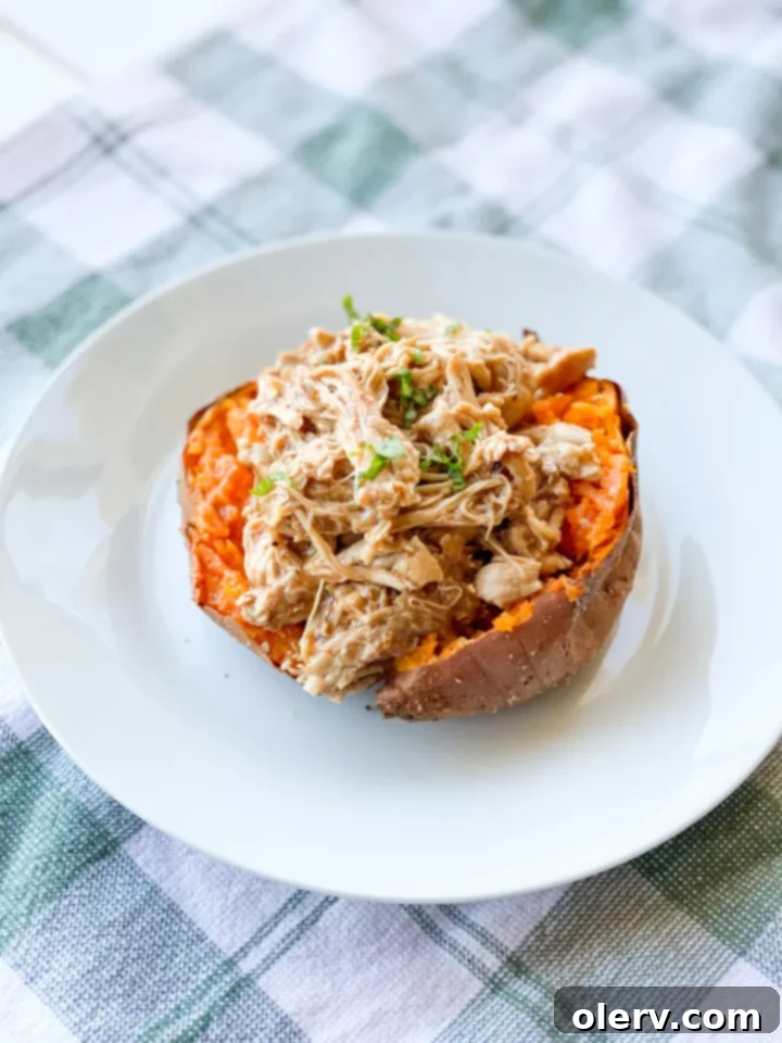Three perfectly baked sweet potatoes, split open and ready to be stuffed, showing their fluffy orange interior.