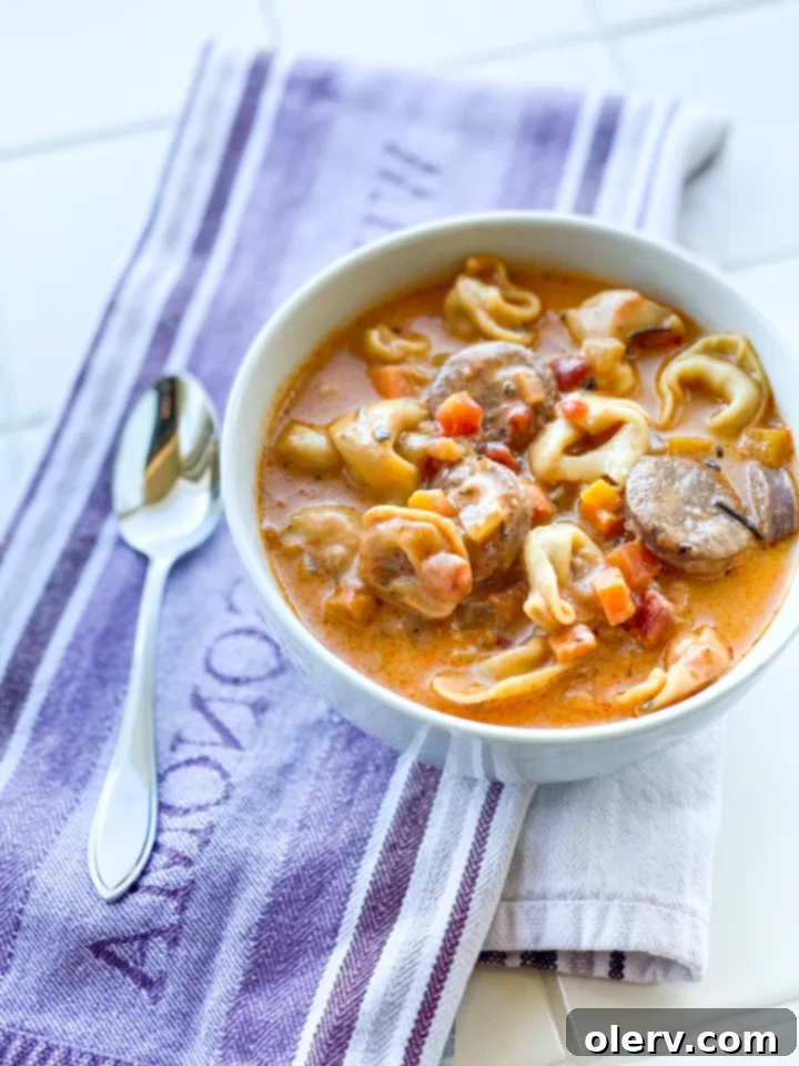 Hearty Sausage and Tortellini Soup 3 Ingredients for sausage and tortellini soup laid out on a cutting board.