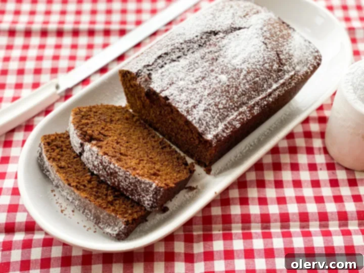 Warm Spiced Gingerbread Loaf 2 A freshly baked, golden-brown homemade gingerbread loaf, dusted with powdered sugar, ready to be sliced and served.