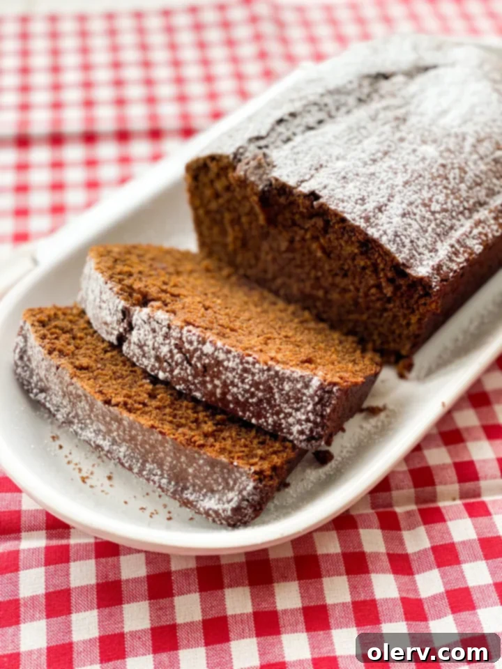 Warm Spiced Gingerbread Loaf 3 A close-up of a gingerbread loaf slice, revealing its moist crumb and rich, dark color, indicating perfect baking.
