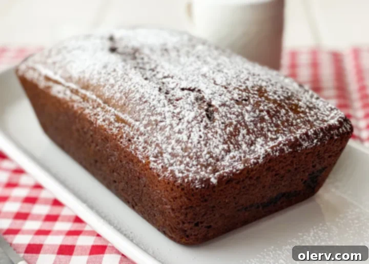 Warm Spiced Gingerbread Loaf 5 A slice of gingerbread loaf, perfectly browned and moist, sitting on a wooden cutting board, inviting a bite.