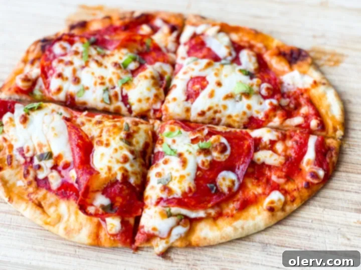 Crispy Air Fryer Pizza 6 Close-up of a pepperoni and cheese air fryer pizza on a naan bread base, perfectly cooked and ready to eat.