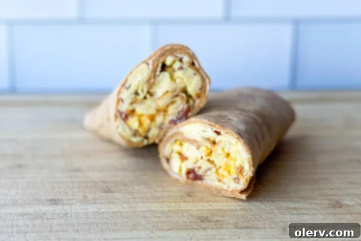 Two halves of a freshly prepared Bacon, Egg, and Cheese Breakfast Wrap