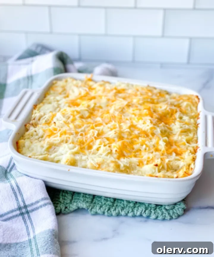 Irresistible Cheesy Potato Gratin 5 Serving scoop taking a portion of the Cheesy Potato Casserole from the baking dish, revealing the creamy interior.