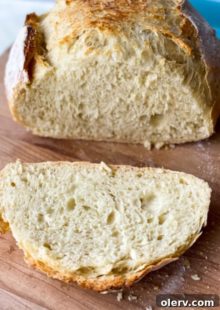 Baking Bread Made Simple 9 A perfectly baked, rustic loaf of homemade bread, golden brown and sliced to show porous interior