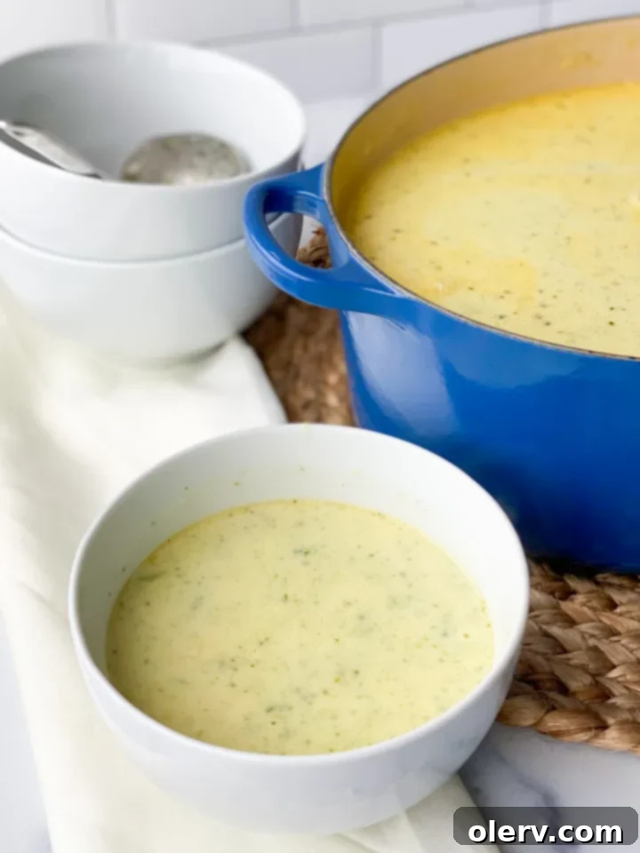 Quick Creamy Broccoli Cheddar Soup 6 A large pot of creamy, bubbling broccoli cheese soup being stirred, showcasing its rich, thick consistency and vibrant color.