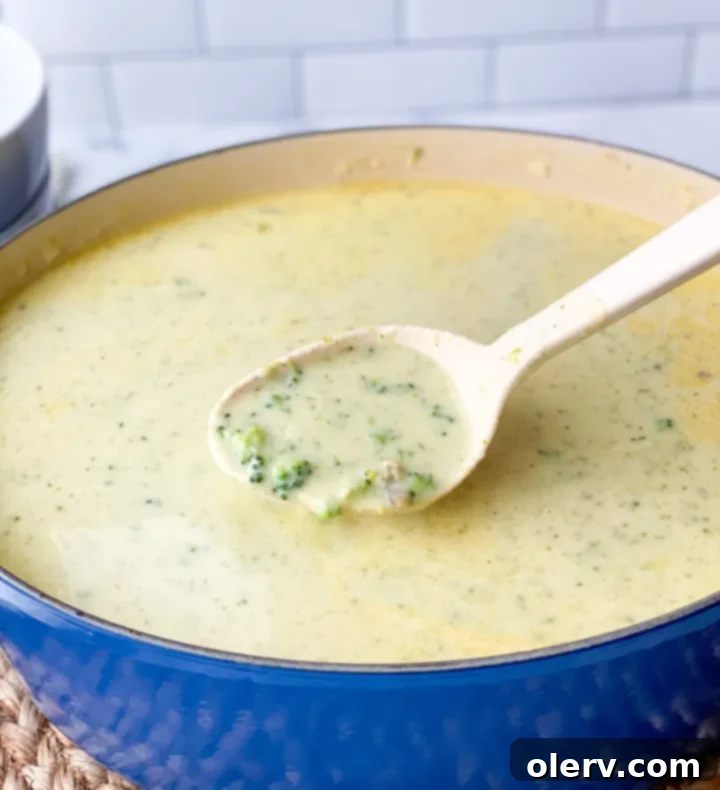 Quick Creamy Broccoli Cheddar Soup 9 A rustic presentation of homemade broccoli cheese soup in a white bowl, accompanied by crusty bread, emphasizing a cozy meal.