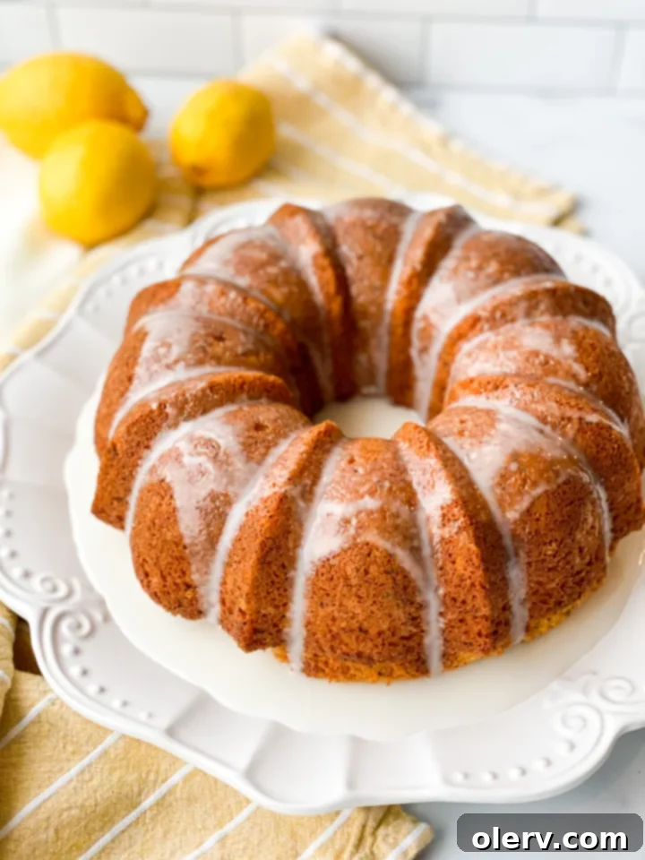 Limon Soslu Haşhaşlı Kek 2 A beautifully golden Poppy Seed Bundt Cake with a luscious lemon glaze drizzled over it, garnished with fresh lemon slices, ready to be served on a rustic wooden board.