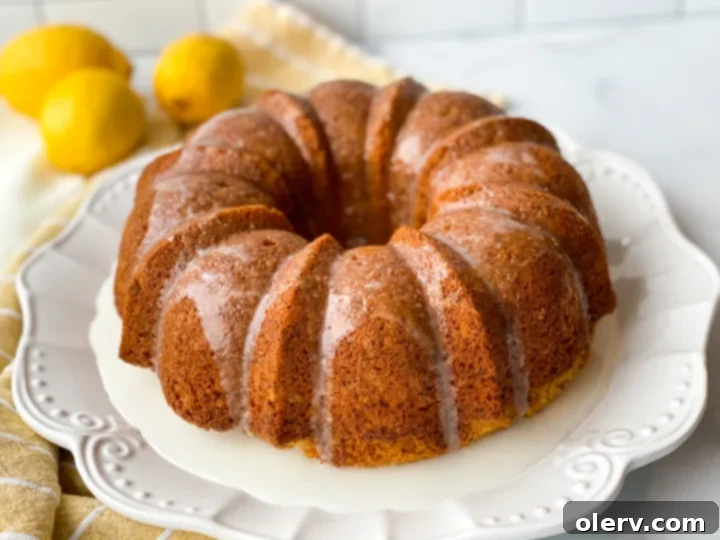 Limon Soslu Haşhaşlı Kek 6 A top-down view of a beautifully glazed Poppy Seed Bundt Cake, with the lemon glaze cascading down its sides, sitting elegantly on a white platter.