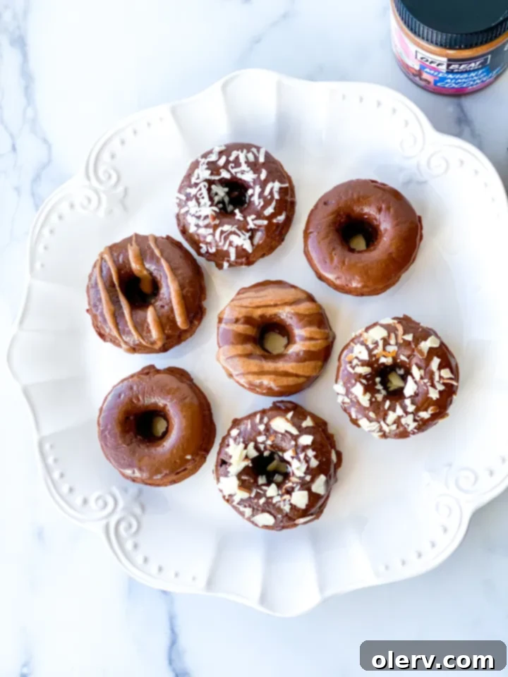 Almond Coconut Donuts: A Midnight Delight 7 A hand dipping a baked donut into a rich chocolate glaze, ready for topping.