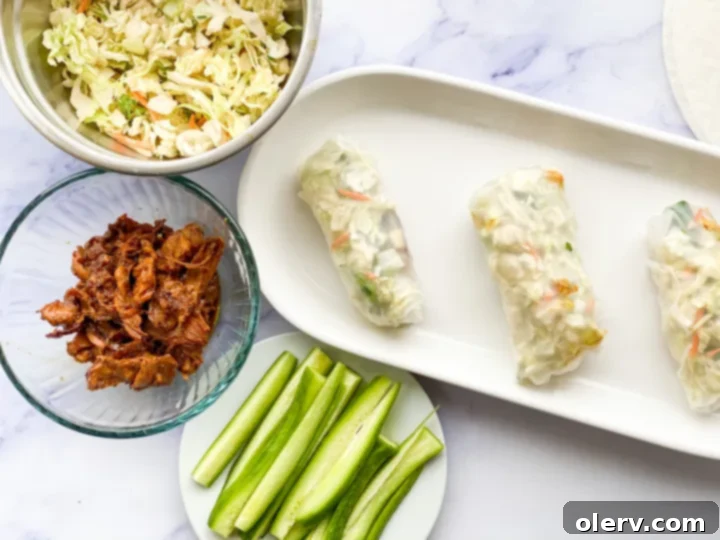 Crispy Chicken Spring Rolls 3 Assorted fresh ingredients for homemade spring rolls, including prepared chicken, chopped vegetables, and rice paper wrappers