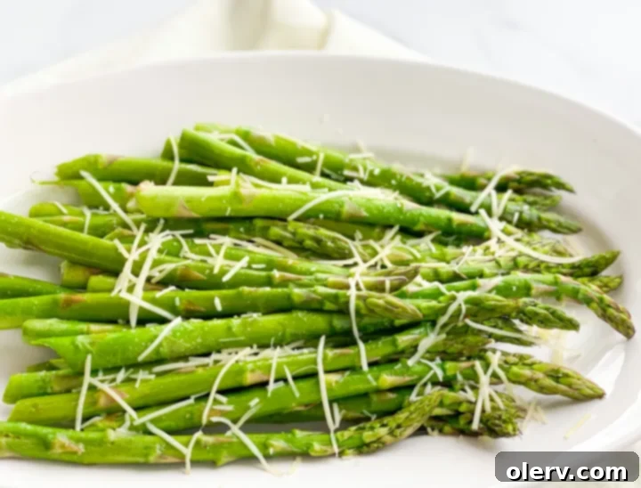 Perfectly Crispy Air Fryer Asparagus 3 Two hands holding a bundle of fresh, uncooked asparagus spears, ready for preparation.