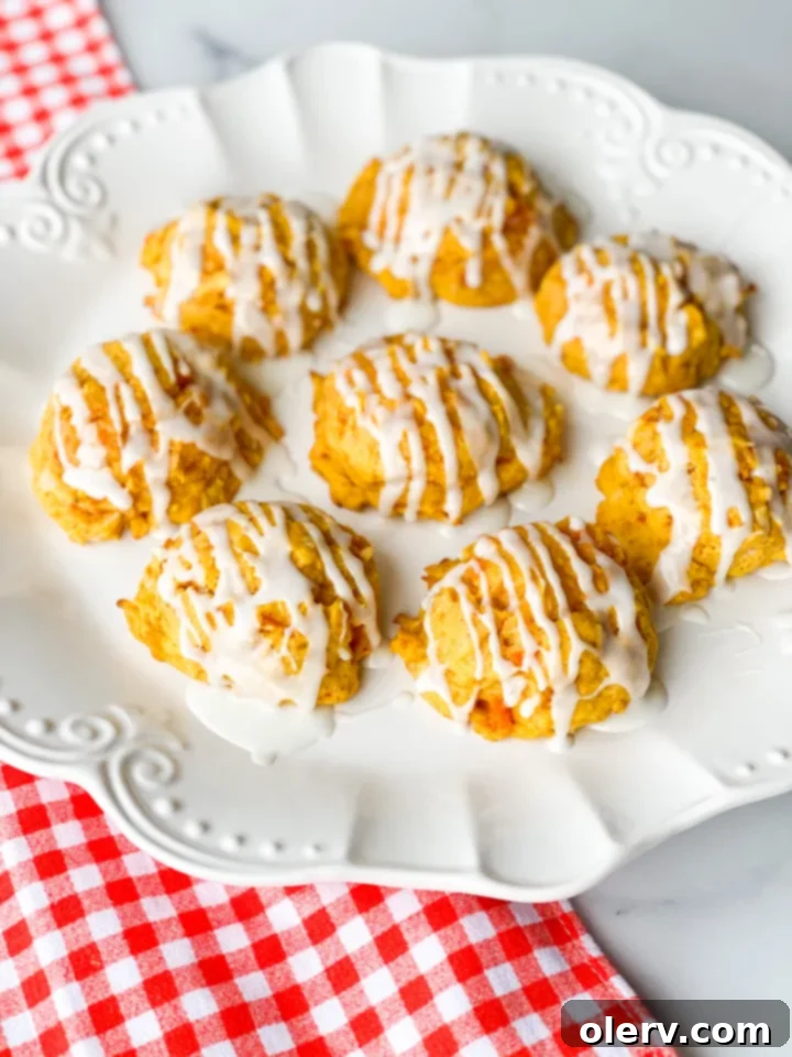 Chewy Spiced Carrot Cake Cookies 2 Freshly baked carrot cake cookies with a sweet icing drizzle on a cooling rack.