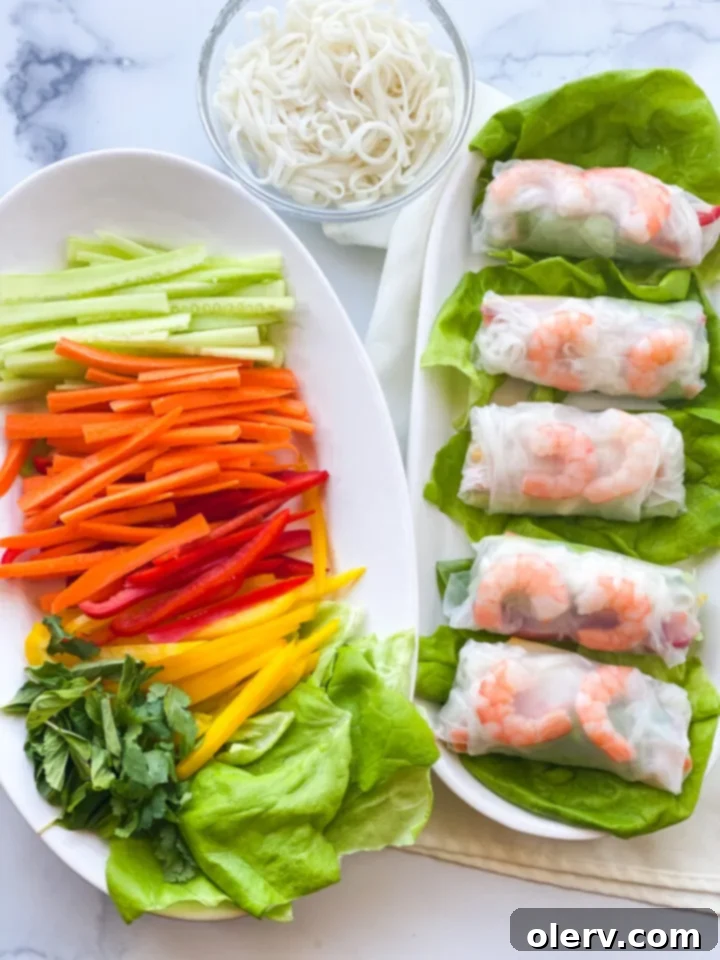 Crispy Homemade Spring Rolls 6 A vibrant assortment of fresh spring rolls on a plate, garnished with fresh herbs and ready for dipping