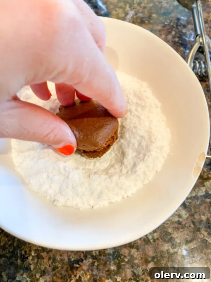 Easy Cake Mix Crinkle Cookies 7 Scooped cookie dough balls, pre-powdered sugar, on a baking sheet.