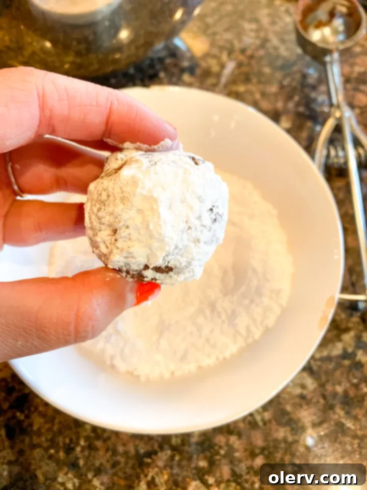 Easy Cake Mix Crinkle Cookies 8 Cookie dough balls generously coated in powdered sugar, ready for baking.