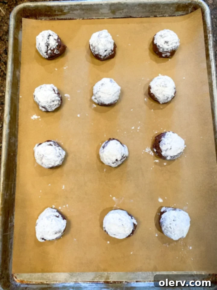 Easy Cake Mix Crinkle Cookies 9 Freshly baked cake mix crinkle cookies cooling on a parchment-lined baking sheet.