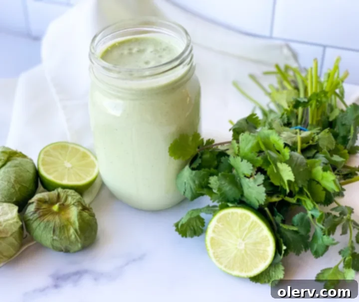 Zesty Cilantro Tomatillo Vinaigrette 5 A vibrant, fresh salad topped generously with creamy cilantro tomatillo dressing, alongside fresh tortillas and a side of seasoned meat.