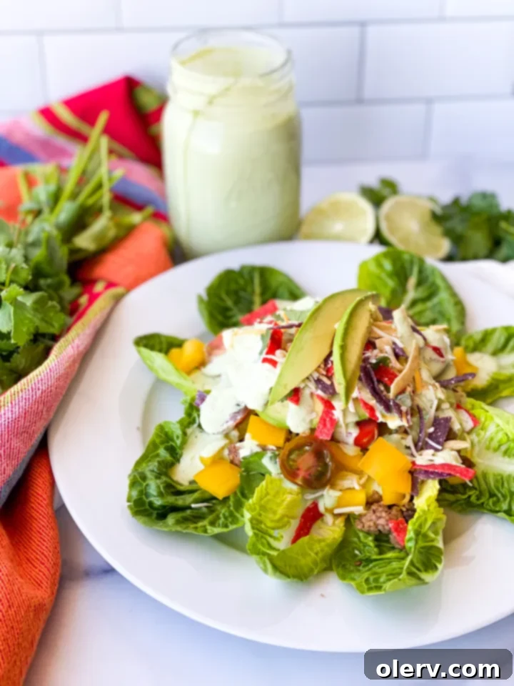 Vibrant Fiesta Taco Salad 2 A vibrant Fiesta Taco Salad with ground beef, beans, avocado, and tortilla strips, drizzled with creamy dressing, ready to be enjoyed.