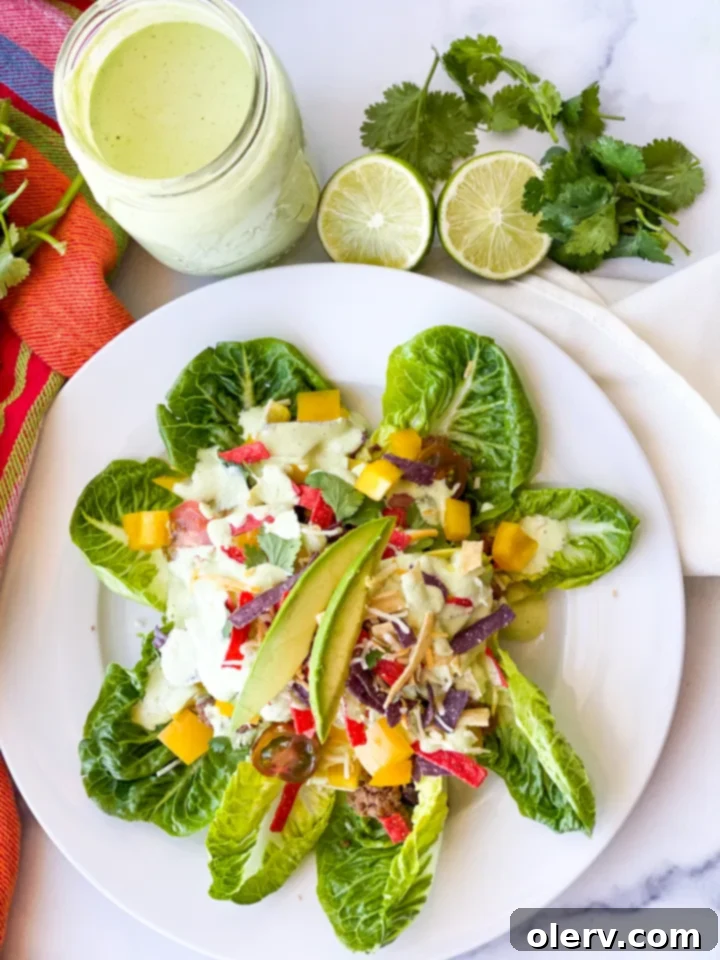 Vibrant Fiesta Taco Salad 4 A hand holding a fork, poised to scoop a bite of the vibrant Fiesta Taco Salad, showcasing the layers of ingredients and the creamy dressing.