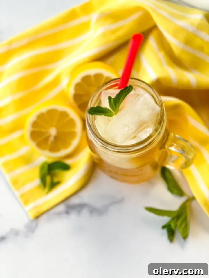 Golden Honey Apple Lemonade 7 A person holding a glass of Honey Apple Lemonade
