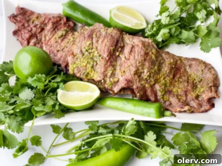 Zesty Cilantro Lime Flank Steak 3 Marinated flank steak on a cutting board with lime and cilantro