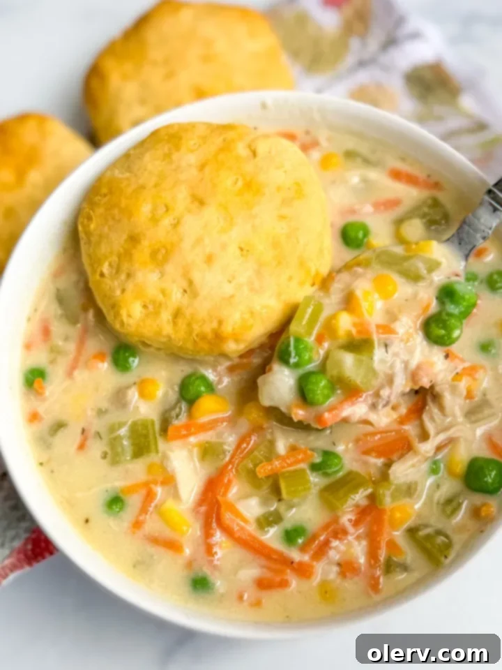 Chicken Pot Pie Soup simmering gently on a stovetop in a large pot